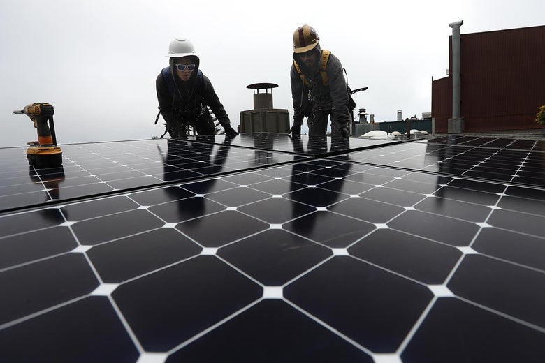 Workers of Luminalt, a solar panel company, install solar panels on the roof of a home on May 9, 2018 in San Francisco, California.
